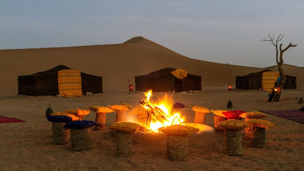 Luxury Morocco desert camp: nomad tents and campfire at Atta Desert Camp in Erg Chigaga